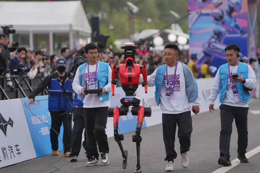 Humanoid robots in red and black suits running the Beijing E-Town Humanoid Robot Marathon 2026, crowds cheering in the background – robotics technology milestone by TopLoveDoll