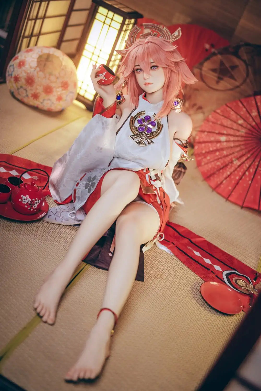  Yae Miko Genshin Impact cosplay sex doll, pink hair, sensual miko outfit, tatami room red cup – anime cosplay sex doll by TopLoveDoll,  red bell anklet, wooden geta sandals, Genshin Impact sex doll, sitting on the floor, holding a J-style red cup