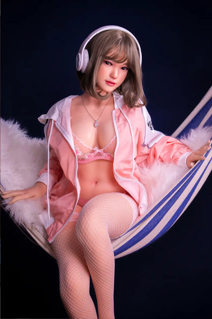 Antonella flaxen bob pear-cut J-style sweet girl in pink tracksuit and blush lace lingerie lounging on blue-white striped hammock with over-ear headphones, sitting on the hammock – curvy Asian sex doll by TopLoveDoll